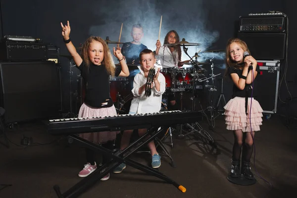 Enfants heureux chantant et jouant de la musique — Photo