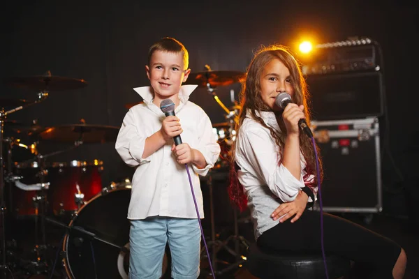 Menino e menina cantando em estúdio de gravação — Fotografia de Stock