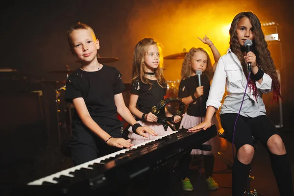 Children singing and playing music in recording studio Stock Image