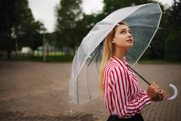 Девушка с прозрачным зонтиком в дождливую погоду — стоковое фото