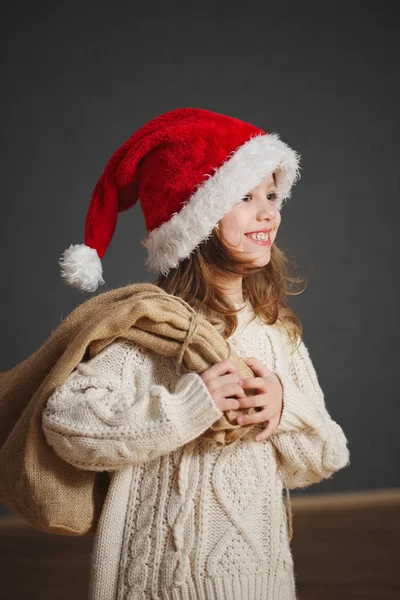 Kleines schönes Mädchen mit rotem Weihnachtsmann-Hut — Stockfoto