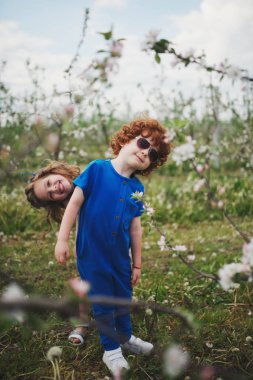 küçük erkek ve kız çiçek açan bahçesinde