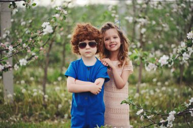 küçük erkek ve kız çiçek açan bahçesinde