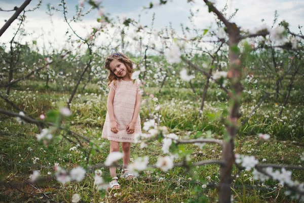 Hermosa niña en el jardín floreciente — Foto de Stock