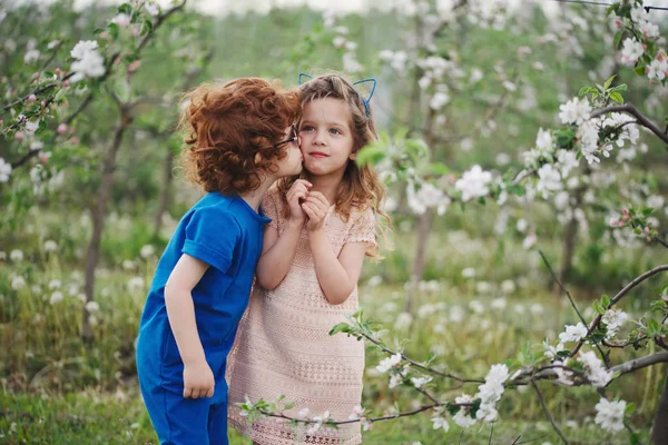 Niño y niña en el jardín floreciente —  Fotos de Stock