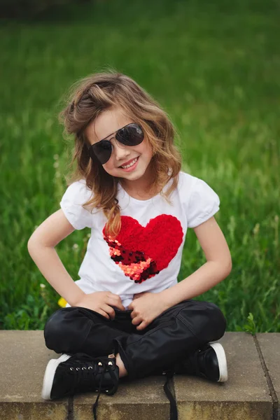 야외에서 앉아 귀여운 웃는 소녀 — 스톡 사진