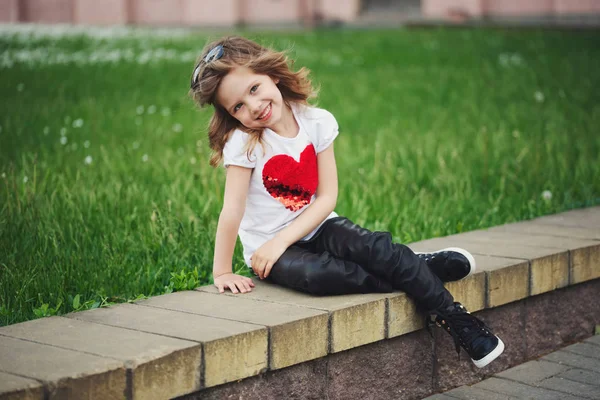 Schattige lachende meisje zit buiten — Stockfoto