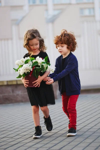 Liten pojke och flicka med stora lila bukett — Stockfoto