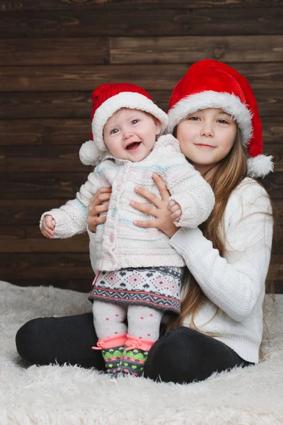 Niedliche glückliche Kinder mit Weihnachtsmützen — Stockfoto