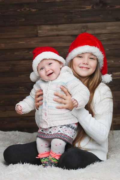 Niedliche glückliche Kinder mit Weihnachtsmützen — Stockfoto