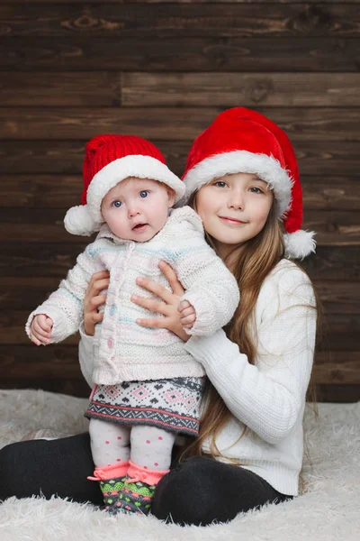 Niedliche glückliche Kinder mit Weihnachtsmützen — Stockfoto