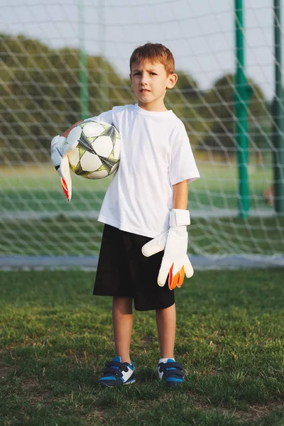 Маленький счастливый мальчик на футбольном поле — стоковое фото