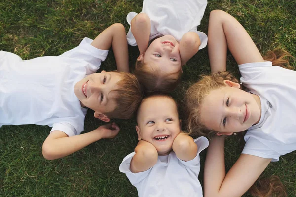 Happy chiuldren ψέματα για την πράσινη χλόη — Φωτογραφία Αρχείου