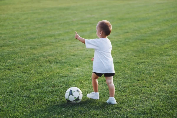 Маленький счастливый мальчик на футбольном поле — стоковое фото
