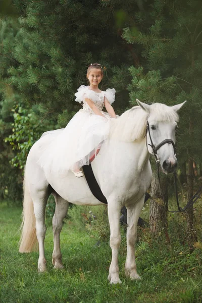 Ευτυχισμένη μικρή πριγκίπισσα στο λευκό άλογο στο δάσος — Φωτογραφία Αρχείου