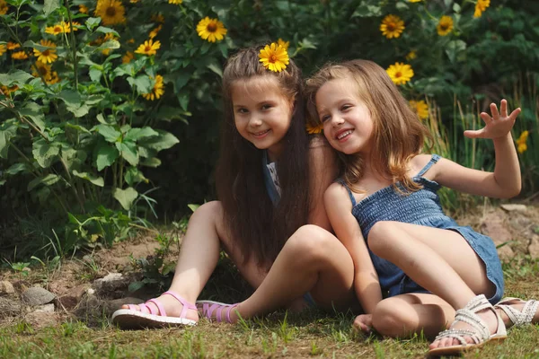 Retrato de chicas hermosas felices en macizo de flores — Foto de Stock