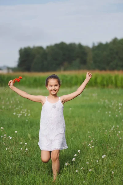 Liten flicka med vallmo på sommaren fält — Stockfoto