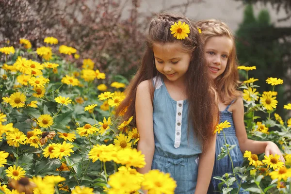 Portrait of happy beautiful girls in flowerbed — Stock Photo, Image