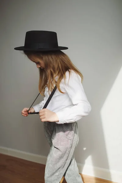 Carino bambina con cappello nero a casa — Foto Stock