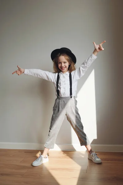 Schattig klein meisje met zwarte hoed thuis — Stockfoto
