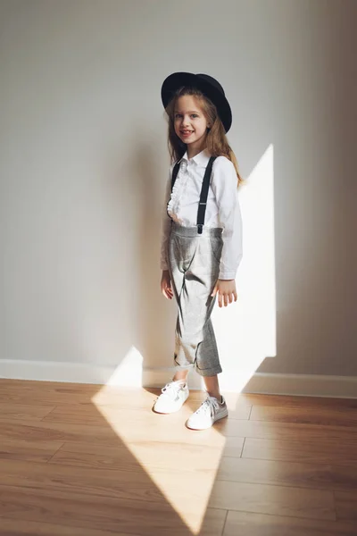 Schattig klein meisje met zwarte hoed thuis — Stockfoto