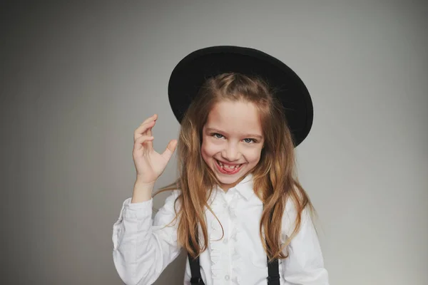 Schattig klein meisje met zwarte hoed thuis — Stockfoto