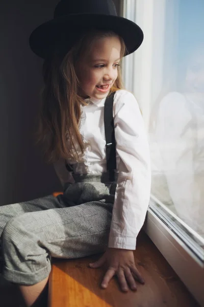 可爱的小女孩与黑帽子在家里 — 图库照片
