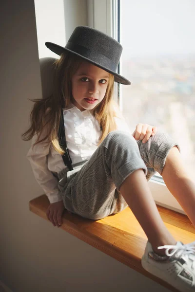 Menina bonito com chapéu preto em casa — Fotografia de Stock