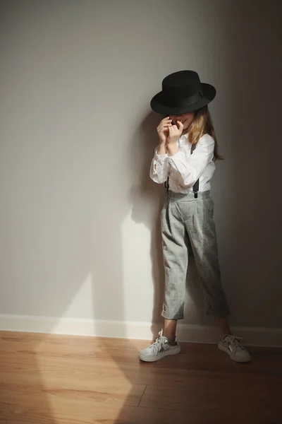 Menina bonito com chapéu preto em casa — Fotografia de Stock