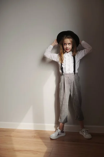 Menina bonito com chapéu preto em casa — Fotografia de Stock