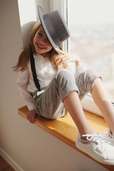 Menina bonito com chapéu preto em casa — Fotografia de Stock