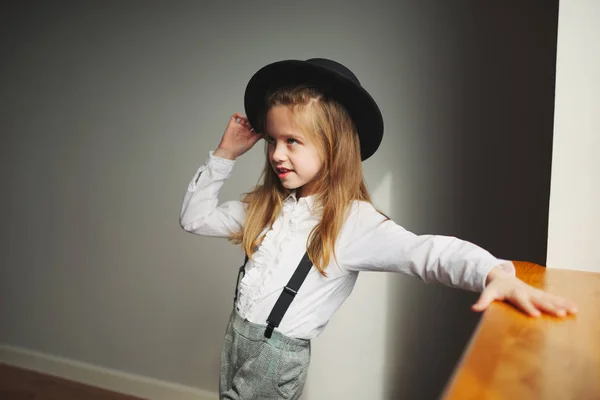 Linda niña con sombrero negro en casa —  Fotos de Stock