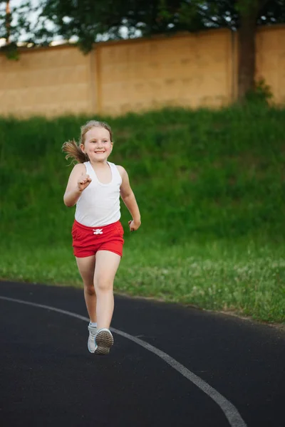 Niña feliz corriendo en el estadio —  Fotos de Stock