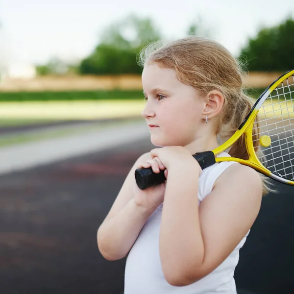 幸せな女の子はコート屋外でテニスを果たしている — ストック写真