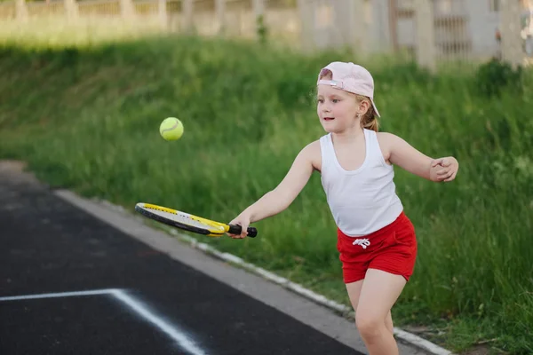 快乐的女孩在户外的网球场上打网球 — 图库照片