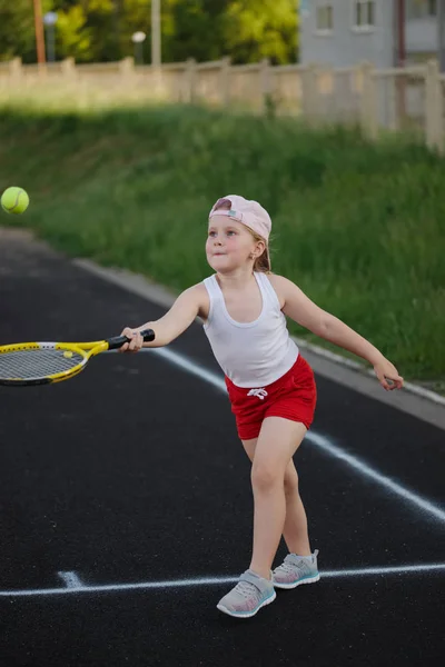 Happy girl plays tennis on court outdoors — Stock Photo, Image