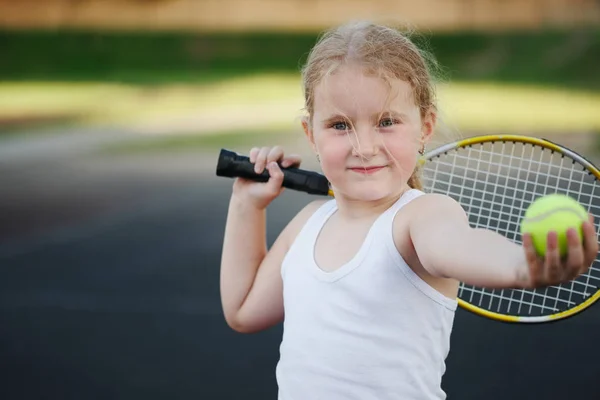 Šťastná dívka hraje tenis na dvoře venku — Stock fotografie