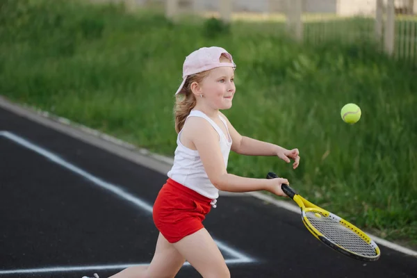 Glücklich Mädchen spielt Tennis auf dem Platz im Freien — Stockfoto