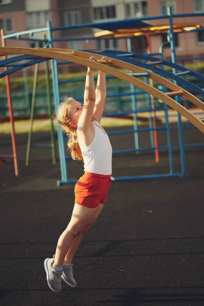 Little girl has fun on monkey bar — Stock Photo, Image