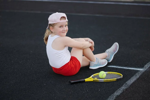 Fille heureuse joue au tennis sur le court en plein air — Photo