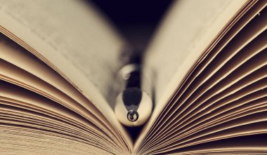 Eski bir kitap açık sayfalarında gümüş kalem Close-up