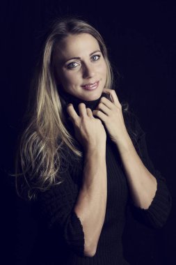 Düşük ışıkta kahverengi deri kanepe sanatsal dönüşüm üzerinde oturan güzel kadın