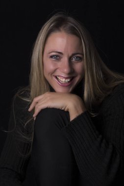 Güzel kadın portre kahverengi deri kanepede oturan düşük ışıkta