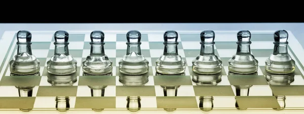 Fila de peões de xadrez de vidro em um tabuleiro com sombra azul e laranja — Fotografia de Stock