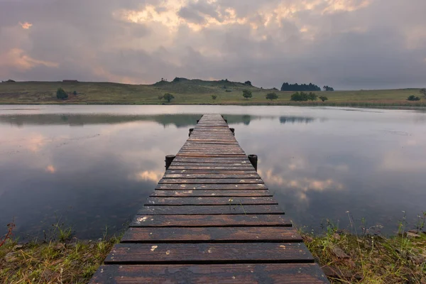 Landschap van een steiger op een dam met dramatische regenwolken — Stockfoto