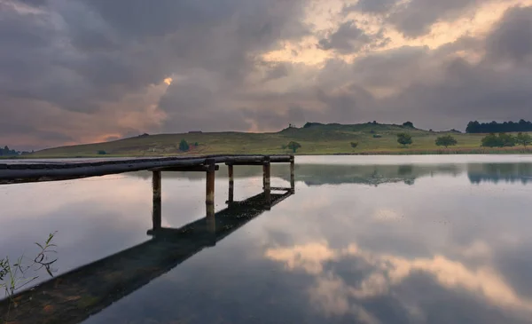 Landschap van een steiger op een dam met dramatische regenwolken — Stockfoto