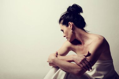 Olgun esmer bir kadının portresi oturup hayatın gerçeklerini düşünüyor.