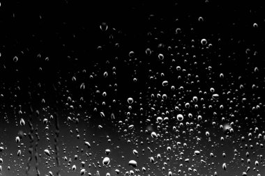 Siyah cam üzerinde yağmur damlaları