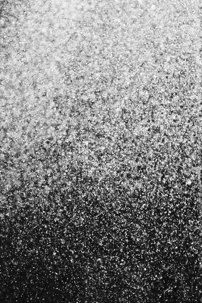 капли воды в воздухе на черном фоне размыты
