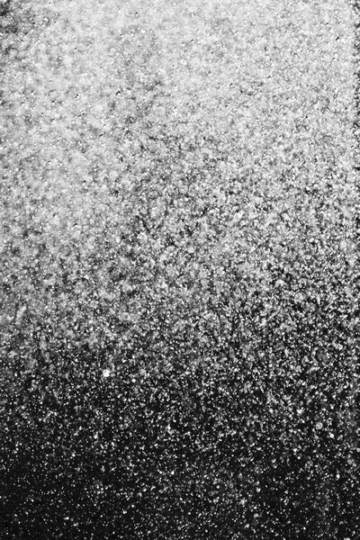 капли воды в воздухе на черном фоне размыты
